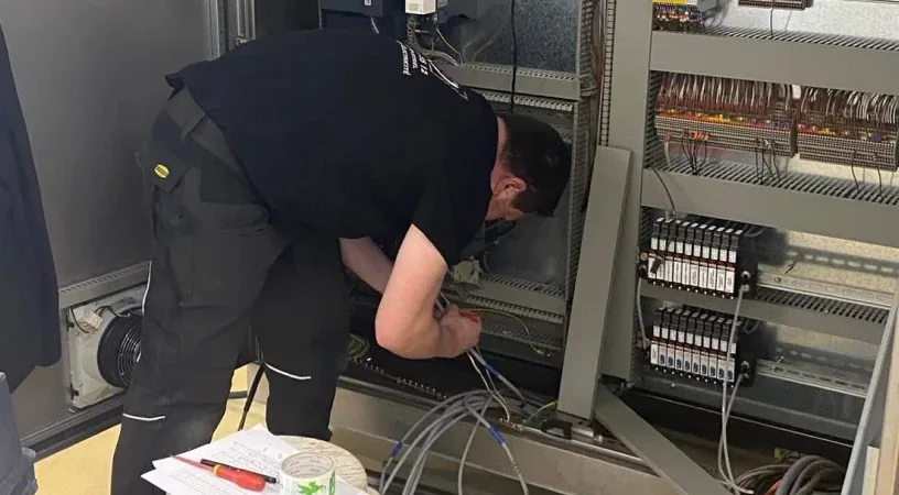Technicien recherchant une panne dans une armoire électrique ouverte