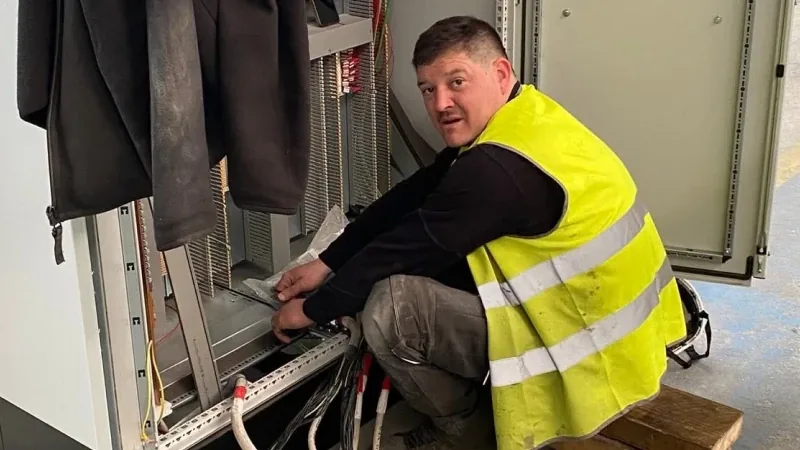 Technicien en gilet haute visibilité intervenant dans une armoire électrique