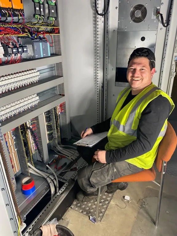 Technicien travaillant sur le raccordement d'une armoire de commande