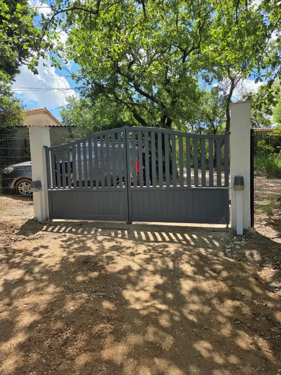 Portail battant motorisé installé à l'entrée d'une propriété