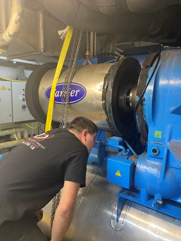 Technicien intervenant sur une machine industrielle bleue